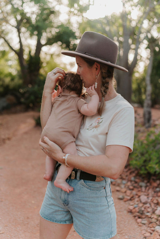 Mum kissing baby on head outdoors