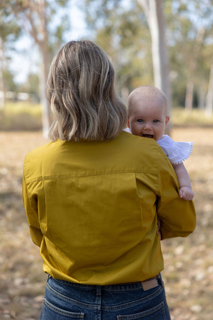 Baby looking over mums shoulder smiling