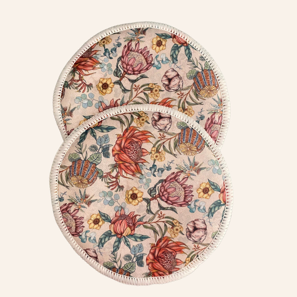 Two round floral-patterned resusable nursing pads on a light background