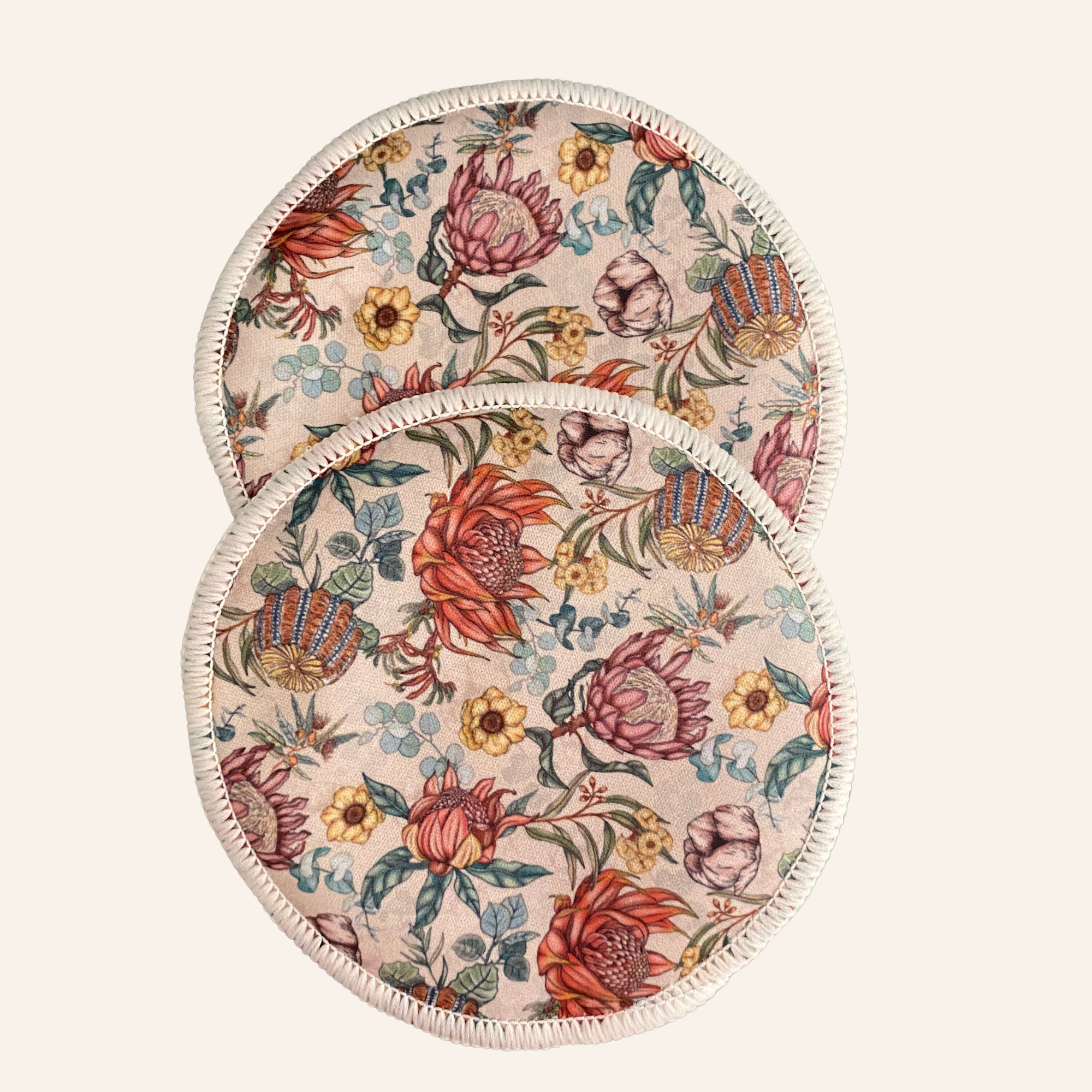 Two round floral-patterned resusable nursing pads on a light background