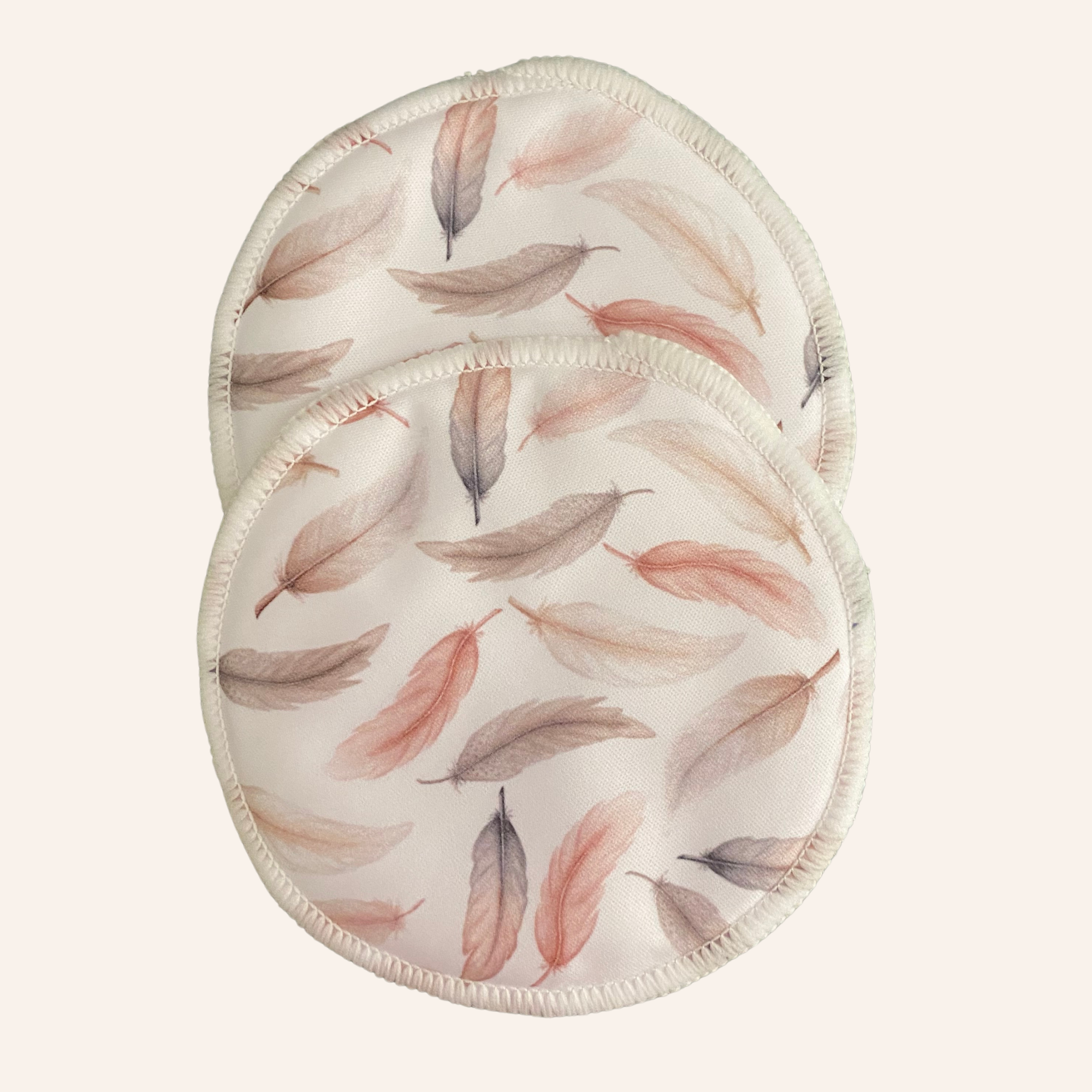 Two round pads with feather pattern on a white background