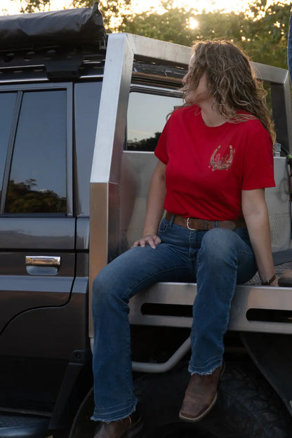Mum sitting on back of ute wearing red tee with bottlebrush and Australian native flower design breastfeeding shirt top