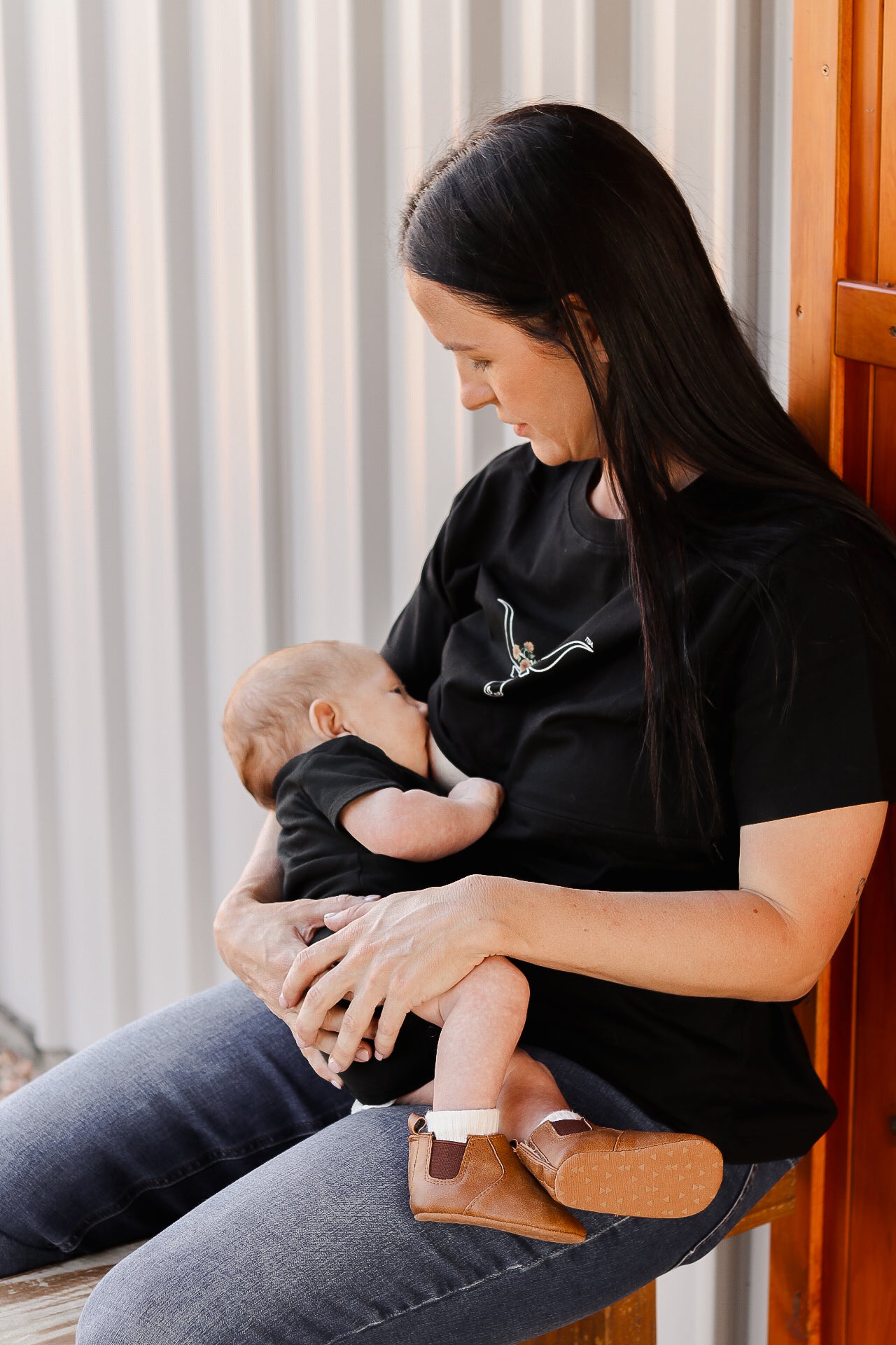 Woman breastfeeding her baby wearing a mum wearing a tittytees breastfeeding shirt