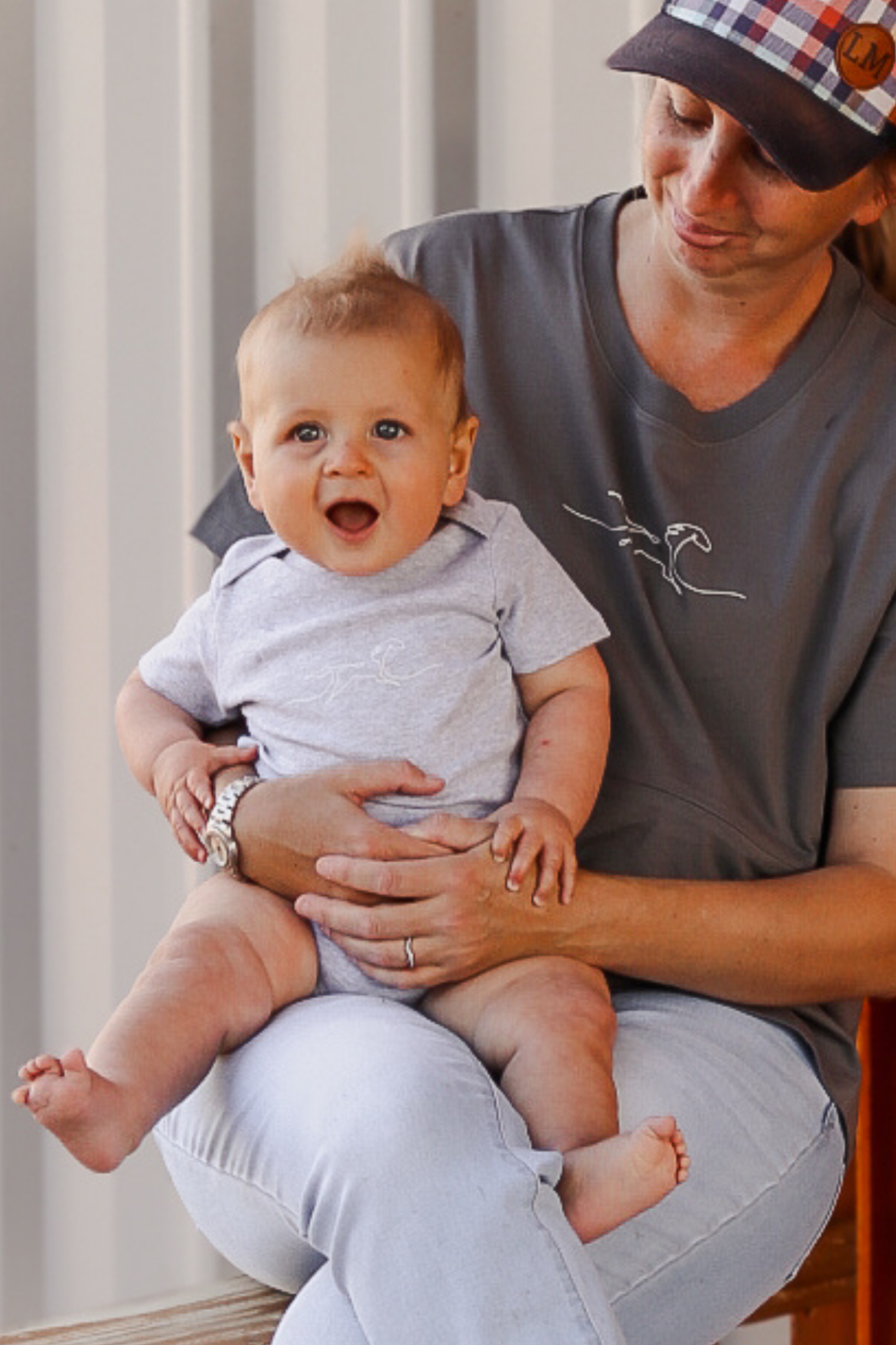 Woman holding a baby in her arms wearing a matching onesies with breastfeeding shirt