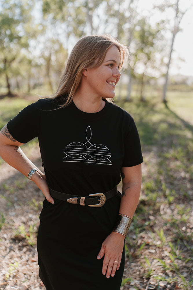Woman wearing a black t-shirt  dress with a white graphic design outdoors