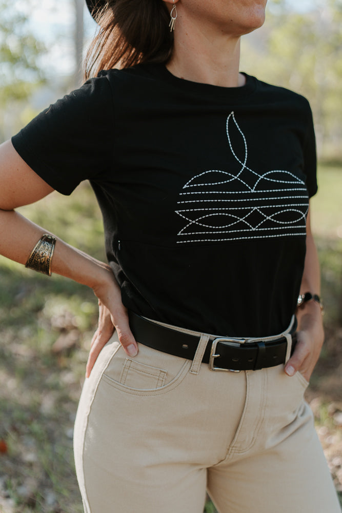 Person wearing a black breastfeeding t-shirt with a white boot stitch design outdoors