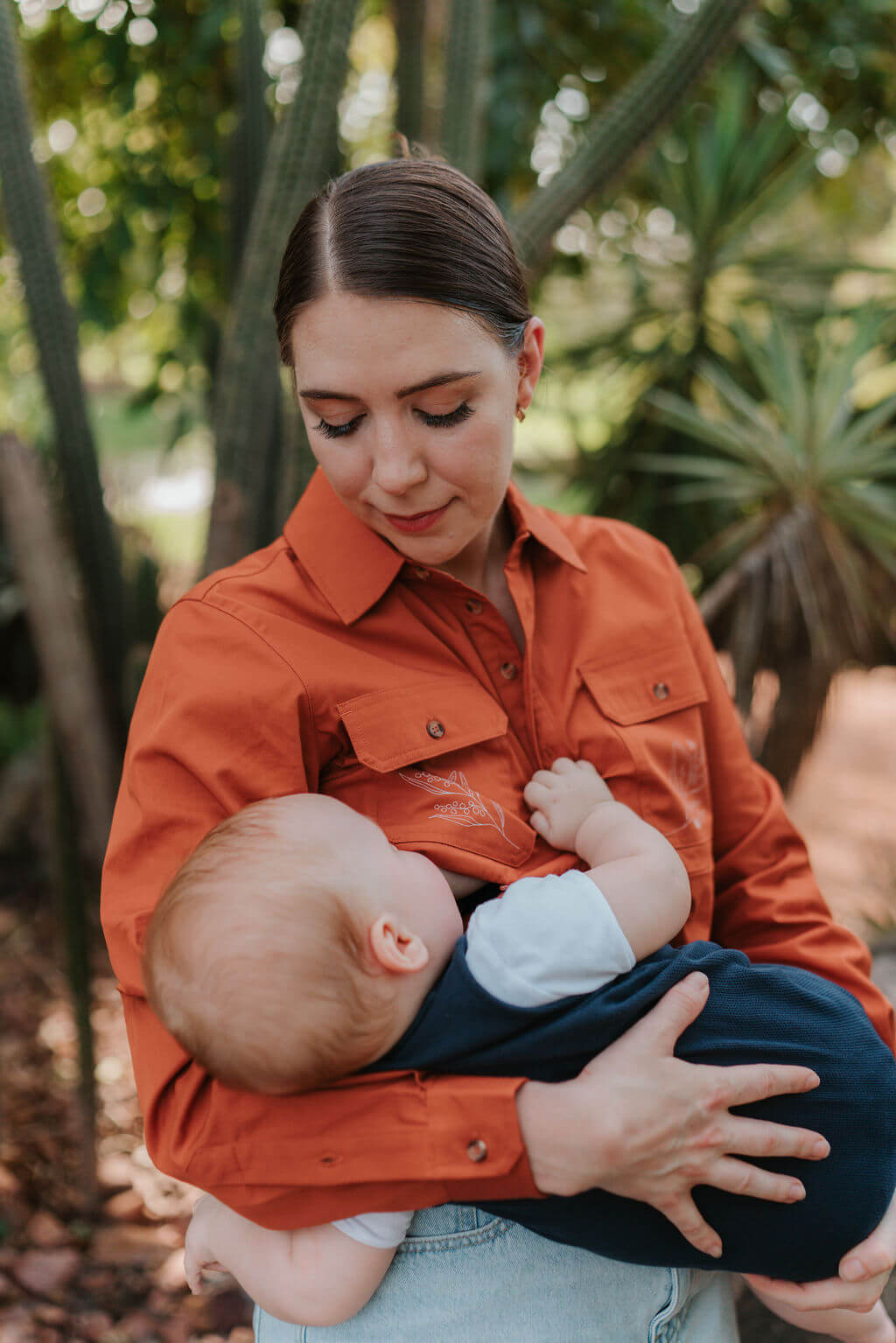 Mum nursing baby while wearing long sleeve shirt from TittyTees
