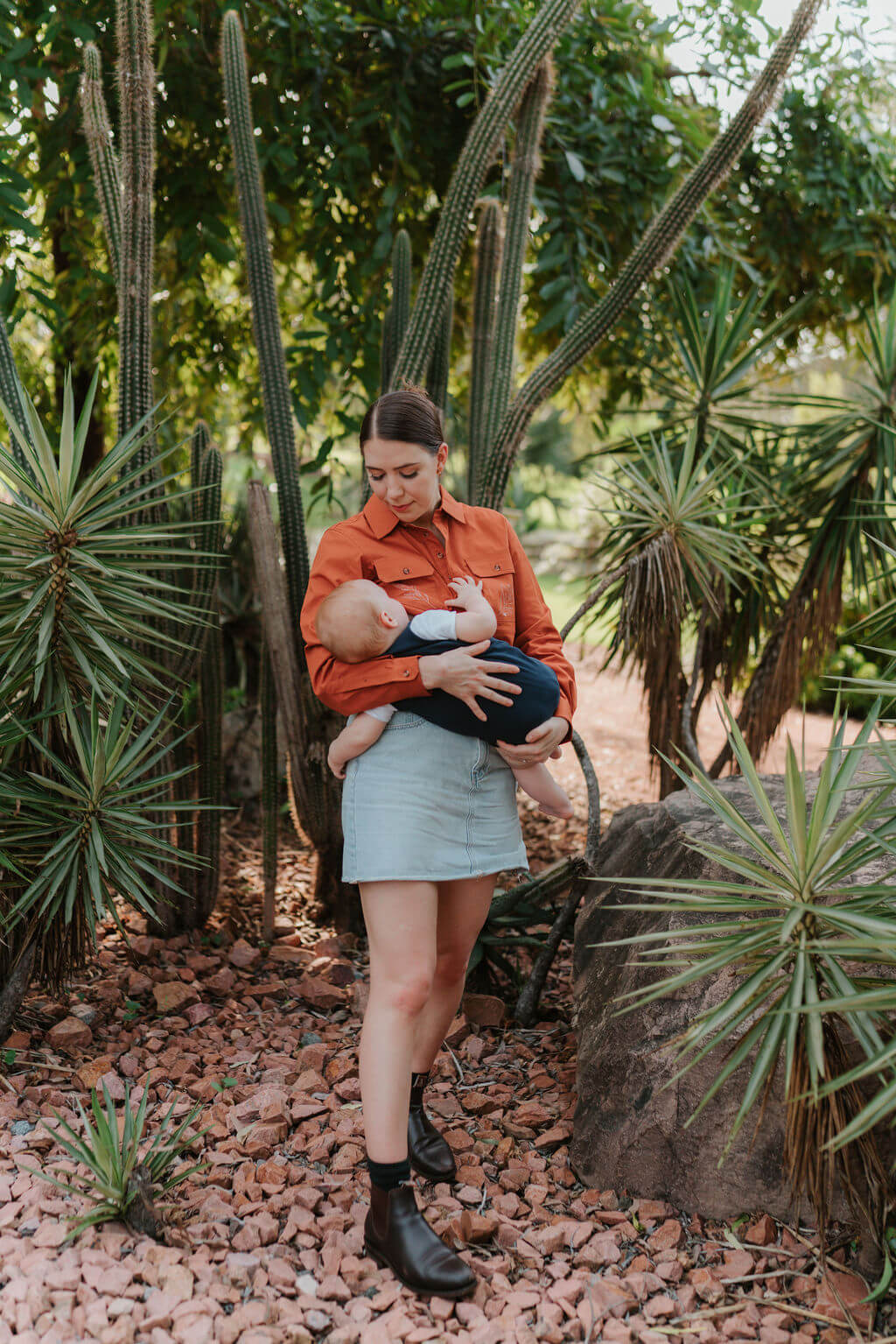 Mum standing while Breastfeeding baby outdoors 